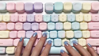 woman with blue nails types softly, pastel marshmallow keyboard